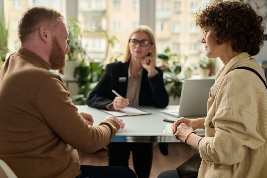Para rozmawia przy stole, podczas gdy adwokat rozwodowy notuje szczegóły.